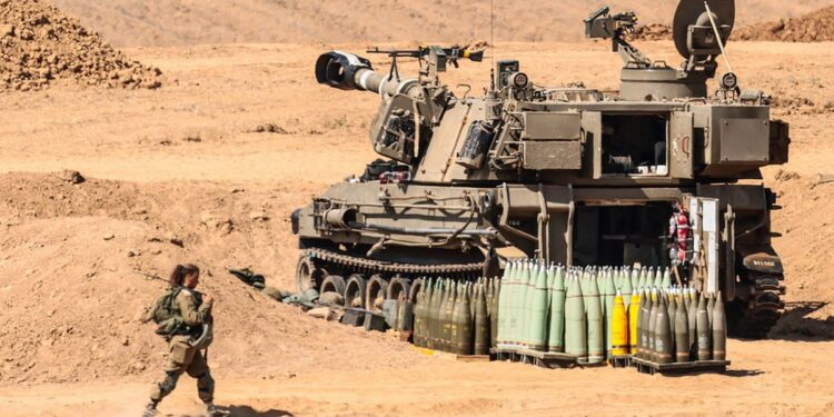 Ισραηλινή στρατιωτικός μπροστά από τεθωρακισμένο του Ισραήλ το οποίο είναι σε θέση μάχης στα σύνορα με τη Γάζα (φωτ.: EPA/Hannibal Hanschke)