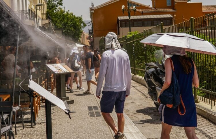 Τουρίστες προσπαθούν να προφυλαχθούν από τη ζέστη στο κέντρο της Αθήνας (φωτ.: EUROKINISSI/Γιάννης Παναγόπουλος)