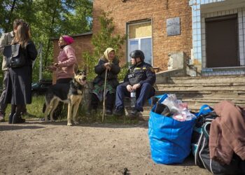 Κάτοικοι χωριού κοντά στο Βοβσάνσκ, τη μεθοριακή πόλη στο Χάρκοβο, περιμένουν τα λεωφορεία που θα τους μεταφέρουν σε ασφαλείς περιοχές (φωτ.: EPA / Sergey Kozlov)