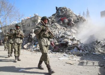 Τούρκοι στρατιώτες περπατούν δίπλα σε ερείπια στην πόλη Καχραμανμαρά, στη διάρκεια του μεγάλου σεισμού τον Φεβρουάριο του 2023 (φωτ. αρχείου: EPA/Tolga Bozoglu)