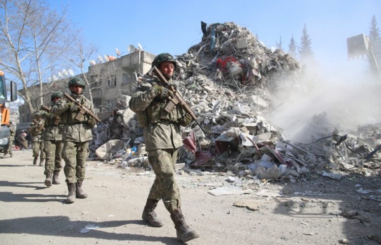 Τούρκοι στρατιώτες περπατούν δίπλα σε ερείπια στην πόλη Καχραμανμαρά, στη διάρκεια του μεγάλου σεισμού τον Φεβρουάριο του 2023 (φωτ. αρχείου: EPA/Tolga Bozoglu)