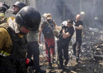 Διασώστες μεταφέρουν τη σορό ενός θύματος πυραυλικής επίθεσης στο Χάρκοβο κατά την οποία σκοτώθηκαν συνολικά επτά άνθρωποι (φωτ.: EPA/Sergey Kozlov)