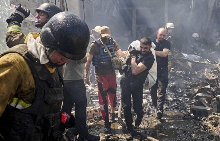 Διασώστες μεταφέρουν τη σορό ενός θύματος πυραυλικής επίθεσης στο Χάρκοβο κατά την οποία σκοτώθηκαν συνολικά επτά άνθρωποι (φωτ.: EPA/Sergey Kozlov)