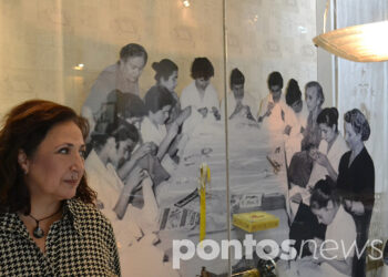 Η πρόεδρος της Μέριμνας, Ανατολή Δημητριάδου, μπροστά σε βιτρίνα έκθεσης κειμηλίων στο μουσείο «Κεντώντας τη Μνήμη» (φωτ.: Αλεξία Ιωαννίδου)
