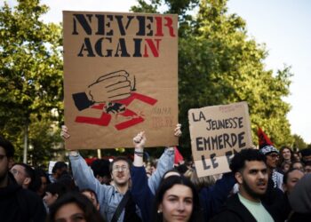 Εκατοντάδες άνθρωποι διαδηλώνουν στο Παρίσι κατά του ακροδεξιού «Εθνικού Συναγερμού» (Rassemblement National) μετά το αποτέλεσμα των ευρωεκλογών, που ώθησαν τον πρόεδρο Μακρόν να προκηρύξει εθνικές εκλογές στη Γαλλία. Το πανό αναγράφει «Ποτέ ξανά», με τονισμένα τα γράμματα RN, από τα αρχικά του ακροδεξιού κόμματος (φωτ.: EPA/Yoan Valat)