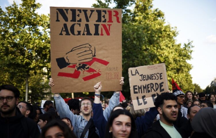 Εκατοντάδες άνθρωποι διαδηλώνουν στο Παρίσι κατά του ακροδεξιού «Εθνικού Συναγερμού» (Rassemblement National) μετά το αποτέλεσμα των ευρωεκλογών, που ώθησαν τον πρόεδρο Μακρόν να προκηρύξει εθνικές εκλογές στη Γαλλία. Το πανό αναγράφει «Ποτέ ξανά», με τονισμένα τα γράμματα RN, από τα αρχικά του ακροδεξιού κόμματος (φωτ.: EPA/Yoan Valat)