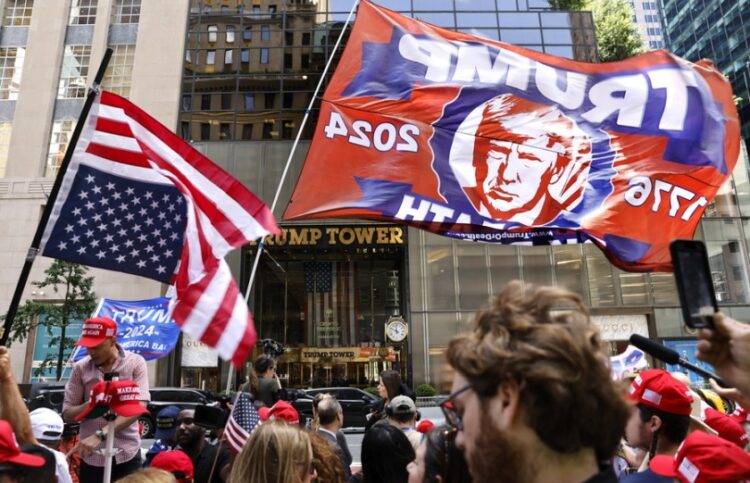 Υποστηρικτές του Ντόναλντ Τραμπ κρατούν σημαίες και πανό έξω από τον Πύργο Τραμπ στη Νέα Υόρκη, μία ημέρα μετά την ανακοίνωση της καταδικαστικής απόφασης κατά του πρώην Αμερικανού προέδρου (φωτ.: EPA/Peter Foley)