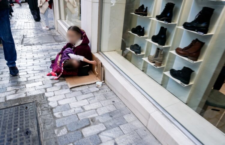 Μικρό κορίτσι με ένα βρέφος στην αγκαλιά ζητιανεύει σε δρόμο της Αθήνας (φωτ.: EUROKINISSI/Γιώργος Κονταρίνης)