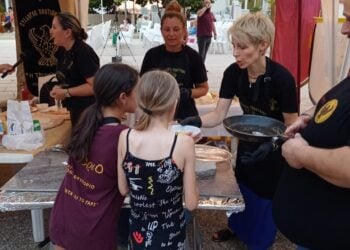 Δύο κοριτσάκια δοκιμάζουν ποντιακές γεύσεις στο «7ο Έτος Ποντιακής Γαστρονομίας», στην πλατεία του Θρυλορίου (φωτ.: facebook / Πολιτιστικός Σύλλογος Ποντίων Θρυλορίου «Η Κερασούντα & το Γαρς»)