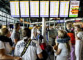 Ταξιδιώτες στο διεθνές αεροδρόμιο Σίπχολ στο Άμστερνταμ κοιτούν τον πίνακα ανακοινώσεων αναζητώντας πληροφορίες για τις πτήσεις τους μετά την κατάρρευση των πληροφοριακών συστημάτων (φωτ.: EPA / Sem van der Wal)