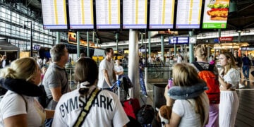 Ταξιδιώτες στο διεθνές αεροδρόμιο Σίπχολ στο Άμστερνταμ κοιτούν τον πίνακα ανακοινώσεων αναζητώντας πληροφορίες για τις πτήσεις τους μετά την κατάρρευση των πληροφοριακών συστημάτων (φωτ.: EPA / Sem van der Wal)