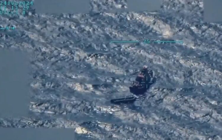 Στιγμιότυπο από το βίντεο, όπου διακρίνεται ένα πλοιάριο να απομακρύνεται από μια βάρκα (φωτ.: X/T.C. Millî Savunma Bakanlığı)