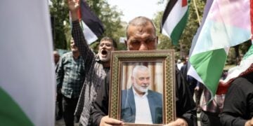 Ιρανοί κρατούν φωτογραφία του Ισμαήλ Χανίγια και παλαιστινιακές σημαίες, στη διάρκεια διαδήλωσης στην Τεχεράνη για τη δολοφονία του πολιτικού ηγέτη της Χαμάς (φωτ.: EPA/Abedin Taherkenareh)