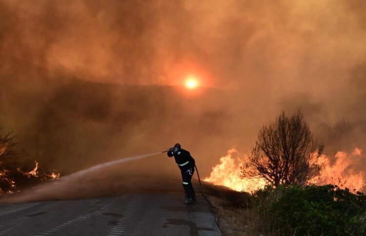 Πυροσβέστης προσπαθεί να περιορίσει τις φλόγες στην Εύβοια (φωτ.: EUROKINISSI/Μιχάλης Παπαδόπουλος)