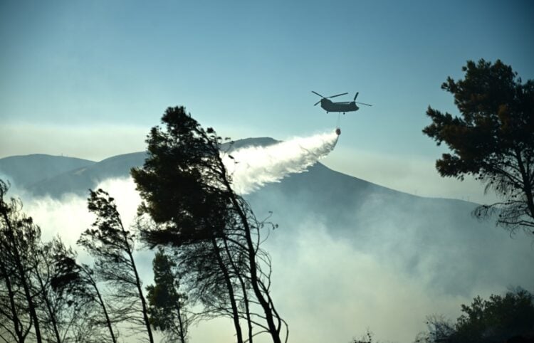 Ελικόπτερο κάνει ρίψεις νερού σε φλεγόμενη περιοχή (φωτ.: EUROKINISSI/Κώστας Τζούμας)