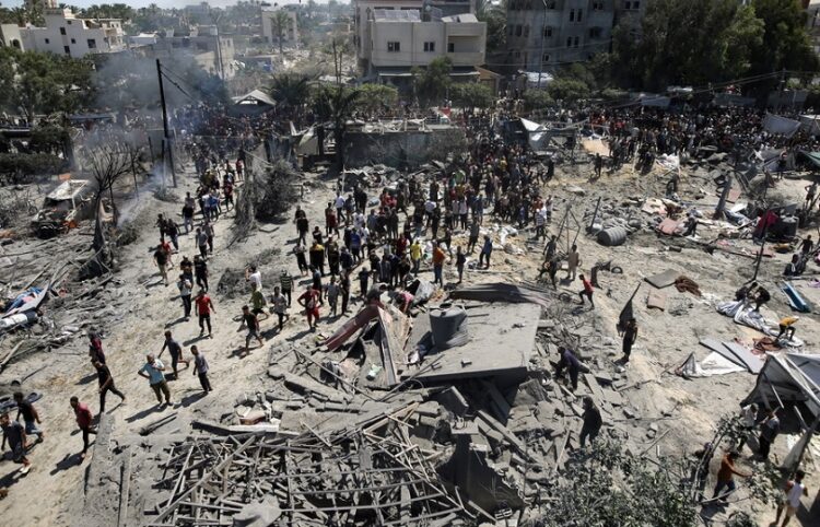 Παλαιστίνιοι επιθεωρούν τα συντρίμμια μετά από ισραηλινή επιδρομή κοντά σε προσφυγικό καταυλισμό στη Χαν Γιουνίς (φωτ.: EPA / Haitham Imad)