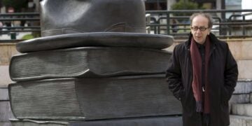 Ο Ισμαήλ Κανταρέ μπροστά στο άγαλμα «Τα βιβλία που μας συνδέουν» στο Οβιέδο της Ισπανίας (φωτ. EPA/Alberto Morante)