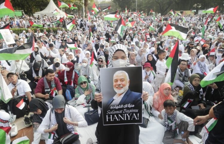 Μουσουλμάνα στην Ινδονήσια κρατά μια φωτογραφία του Ισμαήλ Χανίγια στη διάρκεια συγκέντρωσης μπροστά από την αμερικανική πρεσβεία στην Τζακάρτα υπέρ του παλαιστινιακού λαού (φωτ.: EPA/Bagus Indahono)