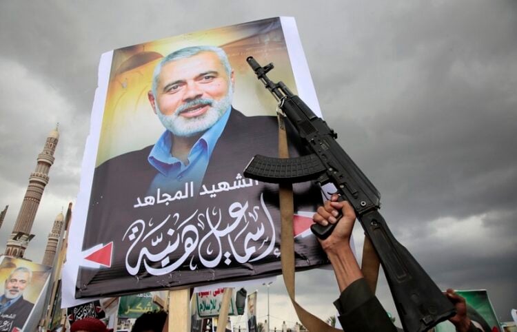Πορτρέτα του Ισμαήλ Χανίγια και όπλα κατά τη διάρκεια διαδήλωσης υποστηρικτών των Χούθι, στη Σαναά της Υεμένης, μετά το θάνατο του πολιτικού ηγέτη της Χαμάς (φωτ.: EPA / Osamah Yahya)