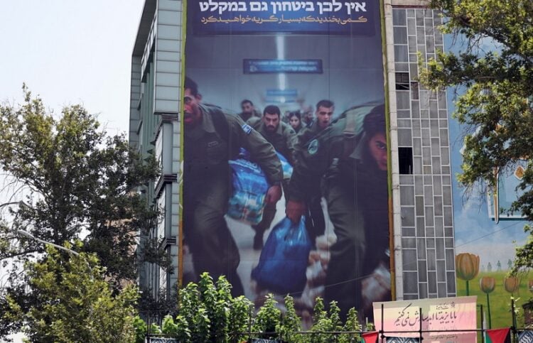 «Χαμογελάστε για λίγο μιας και σύντομα θα κλάψετε πολύ» γράφει το πανό που έχει αποδέκτη τους Ισραηλινούς και είναι αναρτημένο σε κτήριο στην Τεχεράνη, στην Πλατεία Παλαιστίνης (φωτ.: EPA / Abedin Taherkenareh)