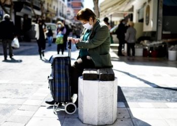 Μία γυναίκα, φορώντας προστατευτική μάσκα για τον κορονοϊό, κάθεται σ΄ ένα παγκάκι στο κέντρο της Κορίνθου (φωτ. αρχείου: ΑΠΕ-ΜΠΕ /Βασίλης Ψωμάς)