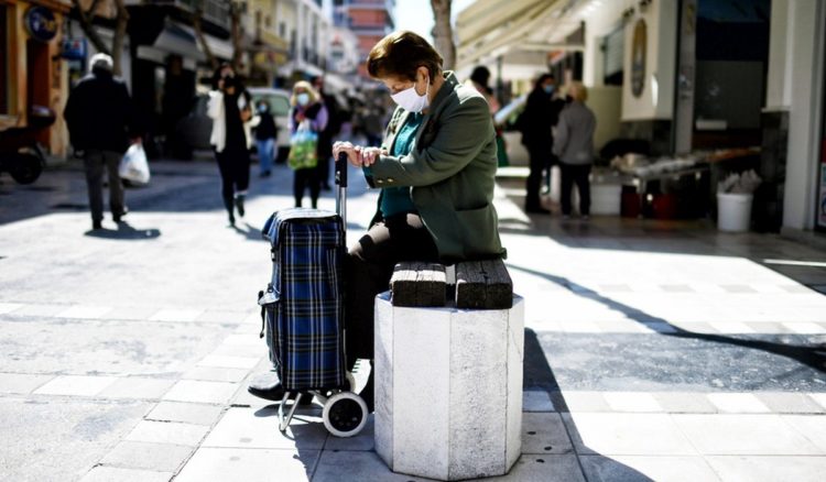 Μία γυναίκα, φορώντας προστατευτική μάσκα για τον κορονοϊό, κάθεται σ΄ ένα παγκάκι στο κέντρο της Κορίνθου (φωτ. αρχείου: ΑΠΕ-ΜΠΕ /Βασίλης Ψωμάς)