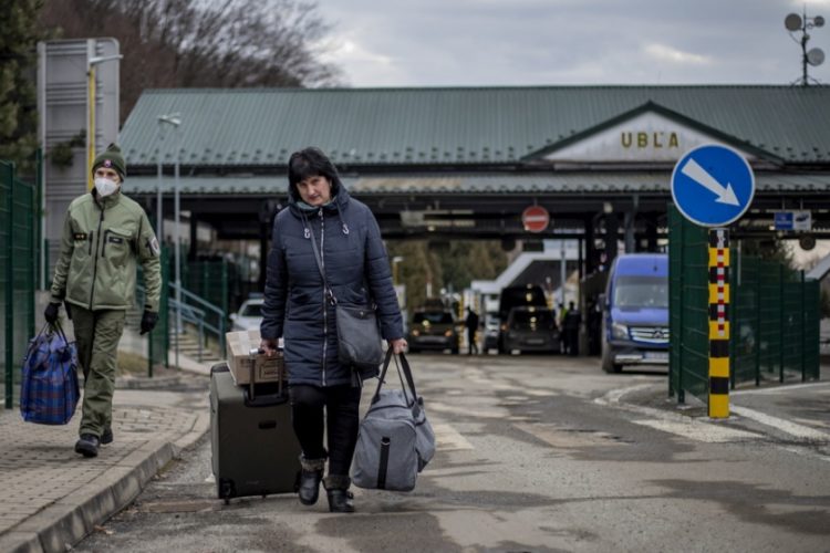 Ουκρανοί πολίτες φεύγουν με τα απαραίτητα από τον τόπο τους για να σωθούν. Εδώ είναι στα σύνορα με τη Σλοβακία
(φωτ.: EPA/MARTIN DIVISEK)