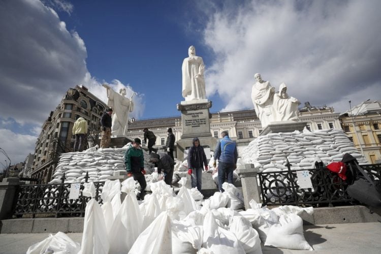 Εθελοντές καλύπτουν με τσουβάλια άμμου το μνημείο της βασίλισσας Όλγας, του Αποστόλου Ανδρέα και των Αγίων Ισαποστόλων Κύριλλου και Μεθόδιου, στο Κίεβο (φωτ.: EPA/ATEF SAFADI)