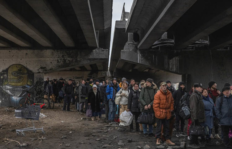 Κάτοικοι της πόλης Ιρπίν, που βρίσκεται στην περιφέρεια του Κιέβου, στην πρώτη γραμμή των μαχών, περιμένουν κάτω από κατεστραμμένη γέφυρα μέχρι να υπάρξει ασφαλής δίοδος (φωτ.: EPA / Roman Pilipey)