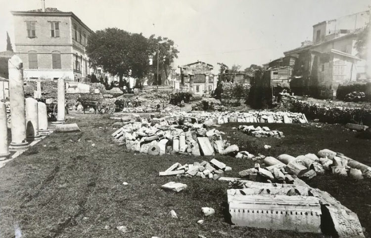 Η Ρωμαϊκή Αγορά το 1930. Στο βάθος διακρίνεται η Πύλη της Αρχηγέτιδος Αθηνάς, η λεγόμενη «Παζαρόπορτα», και δεξιά ξύλινα προσφυγικά παραπήγματα (φωτ.: Διεύθυνση Διαχείρισης Εθνικού Αρχείου Μνημείων ΥΠΠΟΑ)