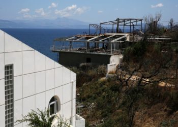 Καμένη ταβέρνα δίπλα σε άθικτο από τη φωτιά κτίσμα ένα χρόνο μετά τη φονική πυρκαγιά στο Κόκκινο Λιμανάκι Αττικής. Η πυρκαγιά ξεκίνησε (23 Ιουλίου 2018) από την Καλλιτεχνούπολη και επεκτάθηκε ταχύτατα στο Μάτι και το Κόκκινο Λιμανάκι. (Φωτ. αρχείου: ΑΠΕ-ΜΠΕ/ Συμέλα Παντζαρτζή)