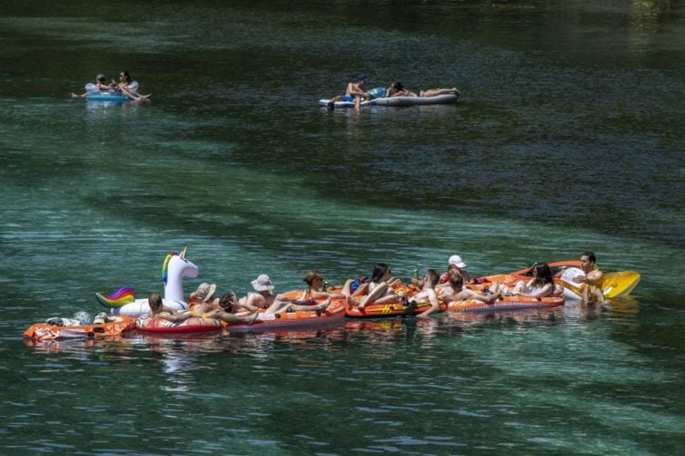 Άνθρωποι με φουσκωτές βάρκες στον ποταμό Ροδανό, στην Ελβετία, τη στιγμή που η θερμοκρασία αγγίζει τους 35 βαθμούς (φωτ.: EPA/ Martial Trezzini)