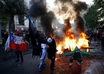 Φλεγόμενα οδοφράγματα στο Σαντιάγο, στις διαδηλώσεις για την 3η επέτειο της κοινωνικής εξέγερσης του 2019 (φωτ.: EPA / Elvis Gonzalez)