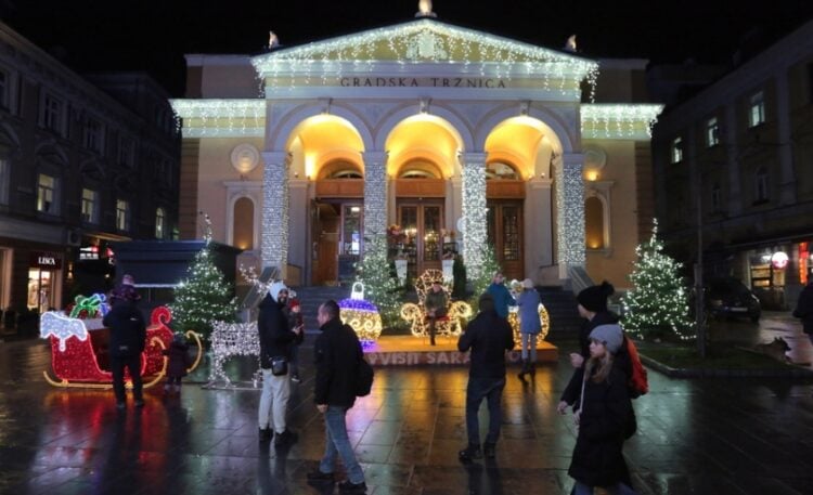 Περαστικοί περιεργάζονται τη χριστουγεννιάτικη διακόσμηση σε κεντρικό δρόμο του Σεράγεβο (φωτ.: EPA/Fehim Demir)