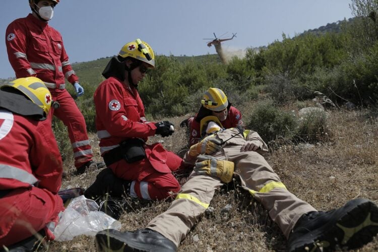 Διασώστες του Ερυθρού Σταυρού δίνουν τις πρώτες βοήθειες σε «τραυματία» πυροσβέστη, κατά τη διάρκεια άσκησης (φωτ.: ΑΠΕ-ΜΠΕ/Κώστας Τσιρώνης)