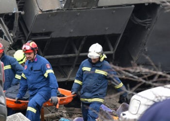 Πυροσβέστες μεταφέρουν σορό από τα συντρίμμια του τρένου (φωτ.: ΑΠΕ-ΜΠΕ / Αποστόλης Ντόμαλης)