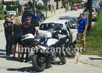 Αστυνομικός διακρίνεται να έχει στην αγκαλιά του το ενός έτους παιδί, το οποίο είχε μείνει μόνο του στο αυτοκίνητο για τουλάχιστον μισή ώρα (φωτ.: Imerazante.gr)