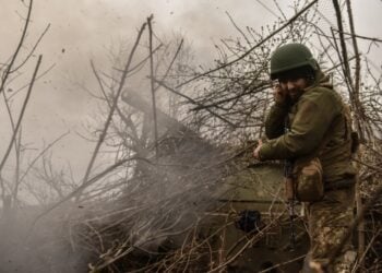 Ουκρανός στρατιώτης στέκεται δίπλα σε άρμα μάχης που ρίχνει βολή έξω από το Μπαχμούτ, στην επαρχία του Ντόνετσκ (φωτ.: EPA/Oleg Petrasyuk)