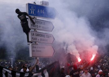 Διαδηλωτής είναι ανεβασμένος σε σηματοδότη, στη διάρκεια ταραχών στη Ναντέρ (φωτ.: EPA/Yoan Valat)