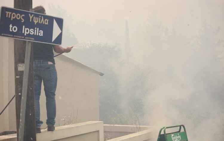 Εθελοντής στις Λούτσες προσπαθεί να περιορίσει τη φωτιά που έχει μπει στο χωριό (φωτ.: EUROKINISSI/Γιώργος Κονταρίνης)