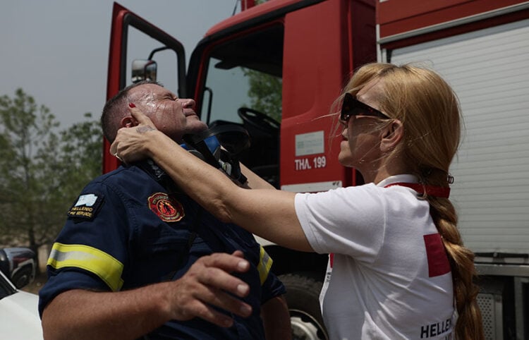 Η φωτογραφία του Βασίλη Ρεμπάπη με τον πυροσβέστη να δέχεται τις πρώτες βοήθειες έγινε viral. Έχει τραβηχτεί στη Νέα Πέραμο, στην περιοχή του Κανδηλίου (πηγή: EUROKINISSI)