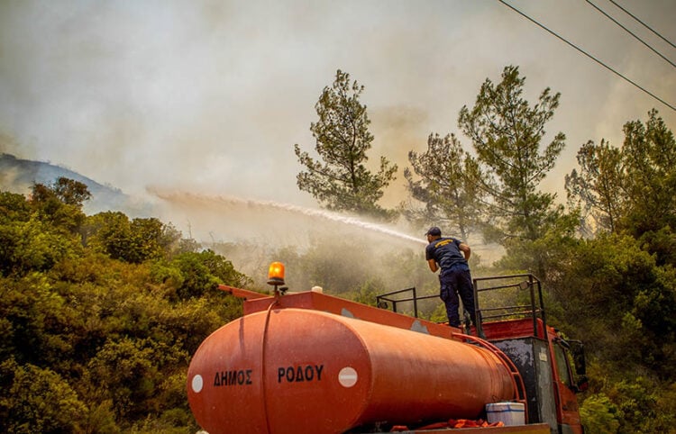 Ρίψη νερού σε μια από τις αναζωπυρώσεις στο Βάτι Ρόδου (φωτ.: EUROKINISSI / Λευτέρης Δαμιανίδης)