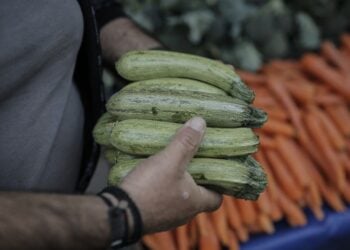 Παραγωγός με τα οπωροκηπευτικά του ανά χείρας, σε λαϊκή αγορά της Αθήνας (φωτ.: ΑΠΕ-ΜΠΕ/Κώστας Τσιρώνης)