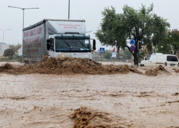 Αυτοκίνητα κινούνται σε πλημμυρισμένο δρόμο στον Βόλο (φωτ.: ΑΠΕ-ΜΠΕ / Νικόλας Χατζηπολίτης)