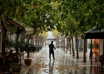 Φθινοπωρινό το σκηνικό στην Κόρινθο, όπου άνδρας κρατώντας ομπρέλα περπατάει σε πεζόδρομο (φωτ.: ΑΠΕ-ΜΠΕ/Βασίλης Ψωμάς)