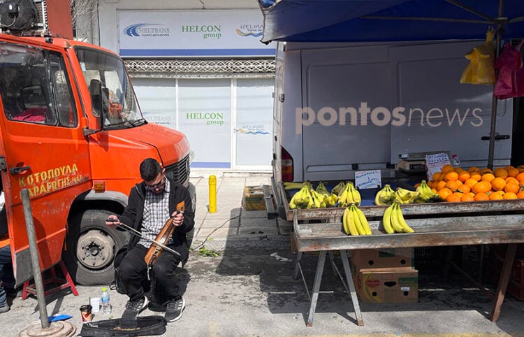 Ο Γιώργος Φωτιάδης στη λαϊκή αγορά των Μετεώρων τραγουδά με τη λύρα του (φωτ.: Γιώργος Κουρκουρίκης)