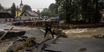 Γυναίκα στην Τσεχία περπατά πάνω από σπασμένη γέφυρα στην πόλη Γεσενίκ μετά από καταρρακτώδη βροχόπτωση (φωτ.: EPA/Martin Divisek)