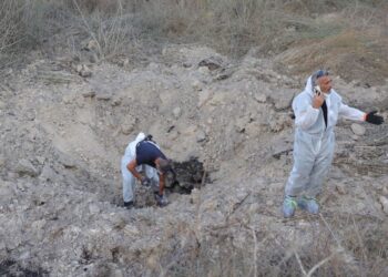 Άνδρες της Μονάδας Εξουδετέρωσης Βομβών της Αστυνομίας του Ισραήλ εξετάζουν το σημείο χτυπήματος πυραύλου εδάφους-εδάφους κοντά στο Kfar Daniel, στο κεντρικό Ισραήλ 
(φωτ.: EPA/ABIR SULTAN)