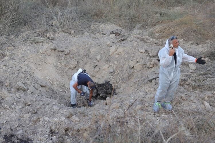 Άνδρες της Μονάδας Εξουδετέρωσης Βομβών της Αστυνομίας του Ισραήλ εξετάζουν το σημείο χτυπήματος πυραύλου εδάφους-εδάφους κοντά στο Kfar Daniel, στο κεντρικό Ισραήλ 
(φωτ.: EPA/ABIR SULTAN)