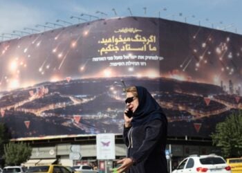 Ιρανή περνάει μπροστά από αντιισραηλινή ηλεκτρονική διαφημιστική πινακίδα στην Τεχεράνη. Πρόκειται για απεικόνιση της πρόσφατης επίθεσης του Ιράν στο Ισραήλ και μια φράση: «Εάν θέλεις πόλεμο, είμαστε οι μάστερ του πολέμου» (φωτ.:  EPA/ Abedin Taherkenareh)